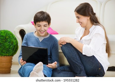 Teen Son With Young Mother With Laptop At Home