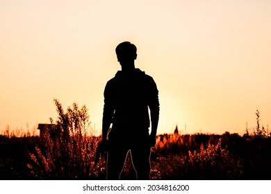Teen standing up during sunset