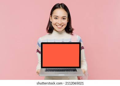 Teen Student Fun Girl Of Asian Ethnicity Wearing Sweater Backpack Hold Books Hold Use Work On Laptop Pc Computer With Blank Screen Workspace Area Isolated On Pastel Plain Light Pink Color Background