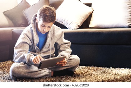 Teen with tablet sitting on the floor in the room - Powered by Shutterstock