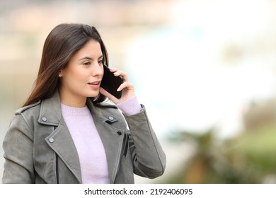 Teen Talking On Mobile Phone Walking In A Park