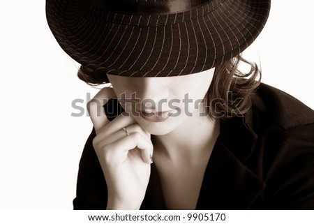 Teen in thinking pose, her eyes hidden under the brim of her pin-striped fedora.  Sepia tone, isolated on white.