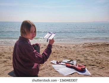 Teen Violinist By The Sea Launches A Paper Airplane