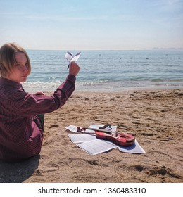 Teen Violinist By The Sea Launches A Paper Airplane