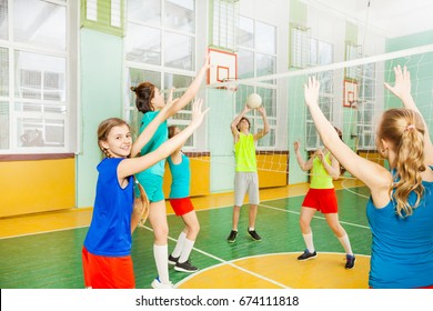 Teen Volleyball Players Having Match In Gymnasium