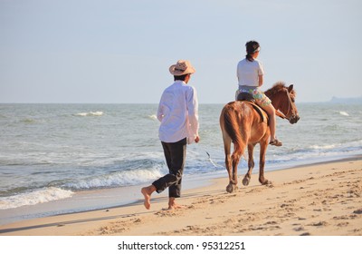 teen women practice to riding a horse on sea beach
