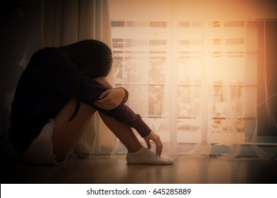 Teenage Asian With Depression Sitting Alone In Dark Room Near The Windows. Major Depressive Disorder.