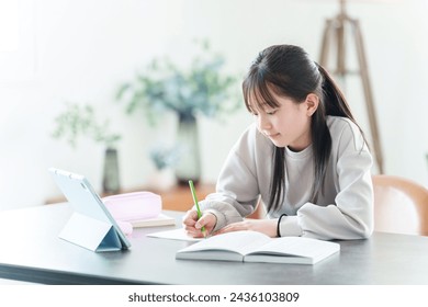 teenage asian girl studying with tablet at home - Powered by Shutterstock