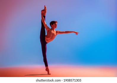teenage ballet dancer dances barefoot under a colored light.