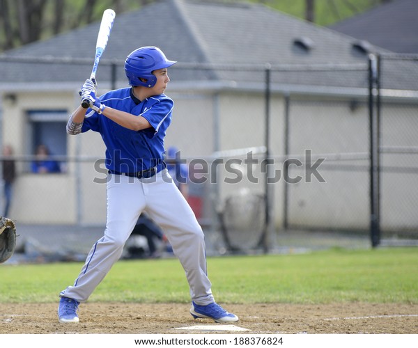 teenage baseball\
player in the batter\'s\
box