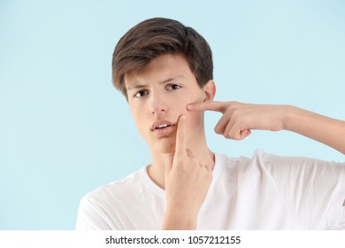 Teenage boy with acne problem on light background