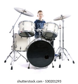 Teenage Boy Behind Drum Kit In Studio Against White Background