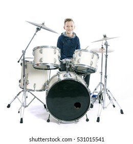 Teenage Boy Behind Drum Kit In Studio Against White Background