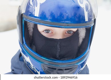 A Teenage Boy In A Blue Helmet And Balaclava. Portrait Of A Child In Winter Close-up.