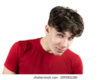 A teenage boy with a cheerful, interested look seems to be spying on someone with the question - What are you doing there? The guy on a white background in a red shirt smiles and spies on someone
