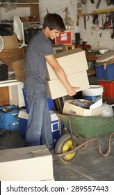 Teenage Boy Clearing Garage For Yard Sale