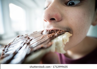 Teenage Boy Close Up Eating Bread With Chocholate Cream