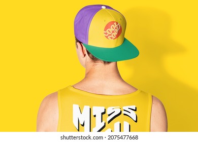 Teenage boy in colorful snapback cap and tank top street fashion shoot rear view