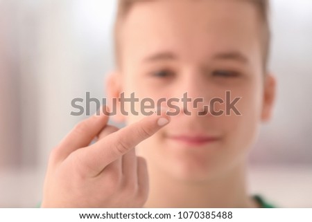 Teenage boy with contact lens on blurred background