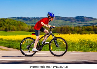 Teenage Boy Cycling On Country Road 