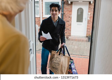 Teenage boy is delivering a bag of shopping to an elderly woman at home.  - Shutterstock ID 1313971673