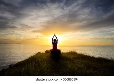 Teenage boy doing yoga at sunset