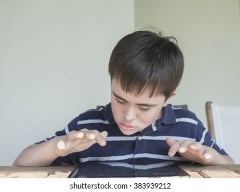 Teenage Boy With Down's Syndrome Using Computer Tablet