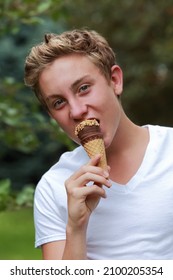 Teenage Boy Eating A Frozen Treat Ice Cream Cone With Nuts, Shallow Focus On Ice Cream Cone