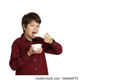 Teenage boy eats yogurt isolated on white background with copy space for text or advertising