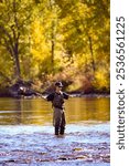 Teenage boy fly fishing on a beautiful autumn day on the Boise River in downtown Boise, Idaho