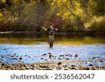 Teenage boy fly fishing on a beautiful autumn day on the Boise River in downtown Boise, Idaho