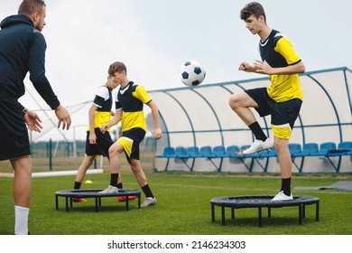 Teenage boy in football training with personal coach. Soccer players improving agility soccer skills. Boy kicking soccer ball standing on fitness trampoline  - Powered by Shutterstock