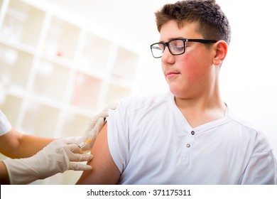 Teenage Boy Getting Vaccination In His Arm, Close Up