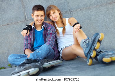 Teenage Boy And Girl Having A Rest After Roller-skating