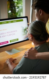 Teenage Boy Helping Grandmother With Ordering Insurance Policy Online