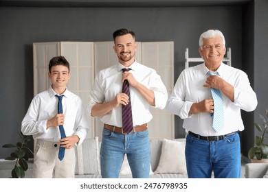 Teenage boy with his dad and grandfather in suits adjusting neckties at home - Powered by Shutterstock