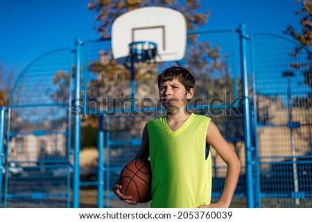 Similar – Teenage boy holding a basketball on a court