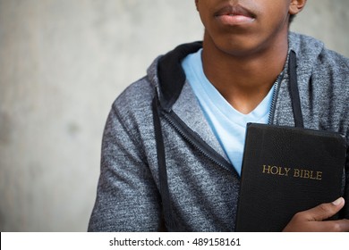 Teenage boy holding a Bible.