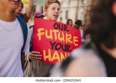 Teenage Boy Holding Poster While Marching Stock Photo 2204153541   Teenage Boy Holding Poster While 260nw 2204153541 