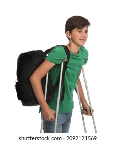Teenage boy with injured leg using crutches on white background
