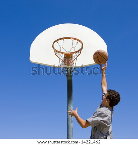 Similar – Foto Bild Junger männlicher Teenager spielt Basketball auf einem Platz im Freien.