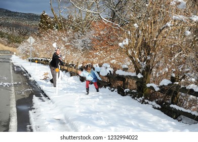 Teenage Boy And Little Girl (mixed Race Brazilian And Japanese) Playing Snowball Fight. Shizuoka Prefecture, Japan. Winter Of February 2011.