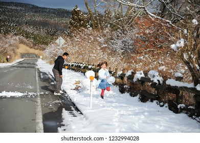 Teenage Boy And Little Girl Playing Snowball Fight. Shizuoka Prefecture, Japan. Winter Of February 2011.