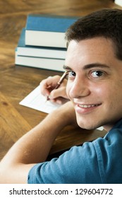 Teenage Boy Looking Over Shoulder Filling Out A College Application