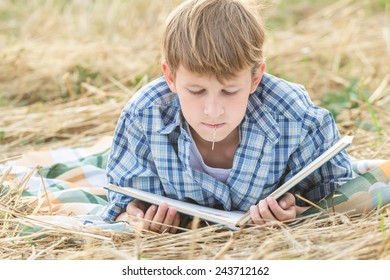 Teenage boy lying with a book outdoor