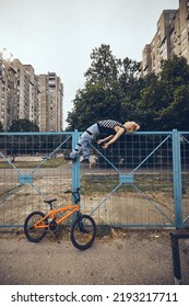 A Teenage Boy Is Lying On The Fence Outside And Feeling Misunderstood.