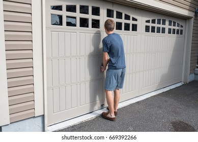 Teenage Boy Opening A Garage  Door, Canada. 