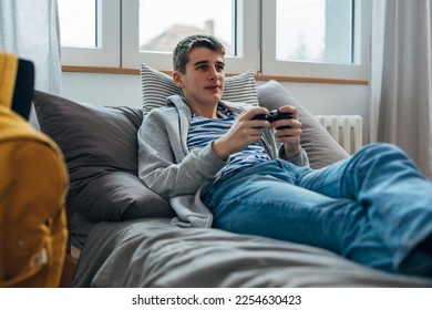 Teenage boy with pimples plays a game at home - Shutterstock ID 2254630423