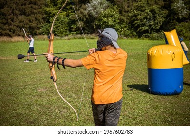 Teenage Boy Playing Archery Tag On A Meadow