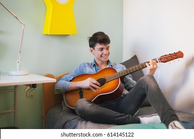 Teenage boy playing guitar in his room - Powered by Shutterstock